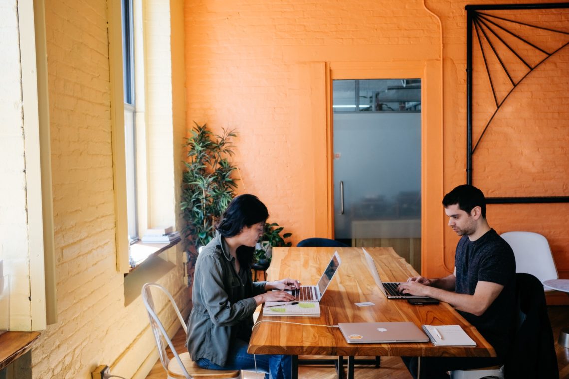 Photograph of two people in a co-working space